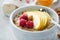 Oatmeal. Bowl of oatmeal porridge with raspberry, pear and honey on gray concrete old table background. Hot and healthy food for