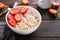 Oatmeal. Bowl of oatmeal porridge with strawberry, almond and milk on old wooden dark table background. Top view in flat lay style