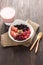 Oatmeal in bowl topped with fresh blueberries, cranberries, strawberries, raspberries, blackberries and berry smoothie