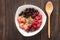 Oatmeal in bowl topped with fresh blueberries, cranberries, strawberries, raspberries, blackberries for healthy breakfast.