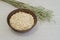 Oatmeal in a brown ceramic bowl with on a background of green ripe ears of oats on a linen tablecloth