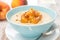 Oatmeal with caramelized peaches in a bowl and jug of yogurt