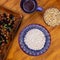 Oatmeal cereal with nut and coffee cup. Healthy breakfast square photo. Morning meal on wooden table top view