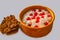 An oatmeal in the clay brown bowl with red currant berries for breakfast is on a white background