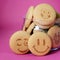 Oatmeal cookies in the form of an emoticon on a pink background. Shortbread cookie for breakfast. Baby biscuits for snacks