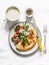 Oatmeal crepes without flour with asparagus, feta, cherry tomatoes and cappuccino - delicious diet breakfast on a dark background