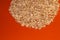 Oatmeal flakes on a bright background. Oatmeal porridge on an orange background