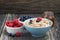 oatmeal, fresh berries and honey on wooden background