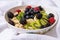 oatmeal, kiwi, berries, blueberries ready to eat on the white table and white plate