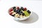 oatmeal, kiwi, berries, blueberries ready to eat on the white table and white plate
