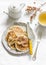 Oatmeal mini crepes without flour with apple cinnamon sauce and green tea on a light background, top view