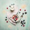 Oatmeal porridge, bottle of milk and berries on blue wooden background with kitchen towel