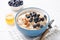 Oatmeal porridge bowl with blueberries, almonds, honey