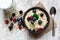 Oatmeal porridge with fresh berries, glass of milk and spoon