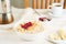 Oatmeal porridge, healthy vegan diet breakfast with strawberry jam, peanut butter, banana, chia on white wooden light background.