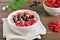 Oatmeal porridge with red and black currant and strawberry