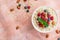 Oatmeal with raspberries, almonds and blueberries and mint  on pink background