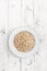 Oatmeal. Rolled oats flakes on white wooden background