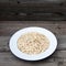 Oatmeal, rolled oats on rustic white wooden background. Food Co