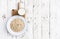 Oatmeal, rolled oats on white wooden background wilt glass of mi
