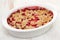 Oatmeal strawberry crumble in white dish on white background