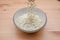 Oats being dropped into a ceramic bowl