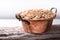 Oats in a copper bowl on a wooden stand side view