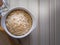 The oats rice in white bowl on top table wood worm tone image