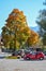 OBERAMMERGAU, GERMANY - OKTOBER 09, 2018: Car and tractor under a yellow tree in the autumn afternoon in Alps