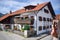 OBERAMMERGAU, GERMANY - OKTOBER 09, 2018: A tourist photographs on phone house with red flowers on balcony