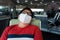 Obese Asian man wearing protective face mask sit sleeping on seat at airport