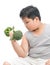 Obese fat boy holding a broccoli dumbbell isolated