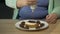 Obese female teenager putting a lot of chocolate dressing over pastry on plate