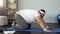 Obese male stretching back muscles, practicing cat yoga pose, fitness exercise