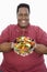 An Obese Man Holding Bowl Of Vegetable Salad