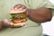 An Obese Man Holding Hamburger