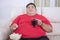 Obese man watching TV with cola and popcorn