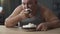 Obese person eating cake with whipped cream greedily and quickly, addiction