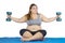 Obese woman doing exercise with dumbbells on mat