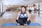 Obese woman meditating in the fitness center