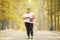 Obese woman standing on road at autumn time