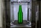 Object green bottle printed on 3D printer close-up, on desktop of 3d printer.