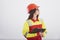 Object overview. Brunette woman in orange and yellow uniform stands against white background in the studio