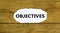 Objectives symbol. The concept word `Objectives` on white paper. Beautiful wooden background. Business and objectives concept