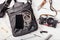 Objects on wooden background: leather bag, camera, smartphone