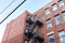 Oblique upward view of an old, generic apartment building with metal fire escape