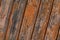 Oblique wood panel vertical strip joints weathered rigid base flaky old orange paint grunge background