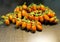 Oblong cherry tomatoes on vine over brown dark wooden table