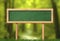 Oblong green blackboard sign forest background