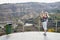 Observation deck and tourist gril on it on the high pace on mountain. Female traveller looking on beautiful landscape from top